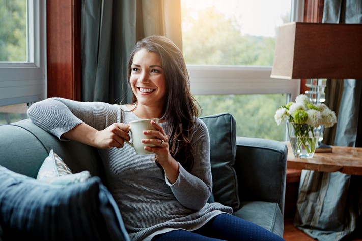 Somfy - woman with coffee cup on couch