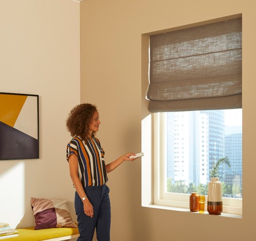 Somfy - woman with remote and roman blind