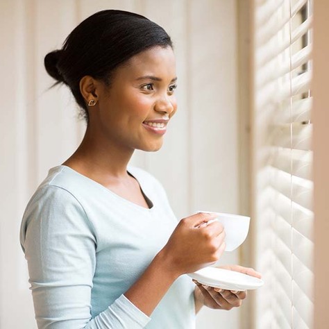 Somfy - woman with coffee cup at window