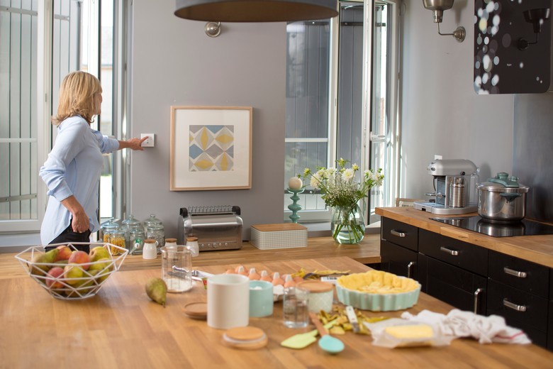 somfy-woman-closes-swing-shutters-kitchen